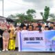 Murid dan guru SD Negeri Parinring Makassar berfoto bersama usai kegiatan berbagi 204 paket takjil kepada warga yang melintas di Jalan Tamangapa Raya, Jumat (13/3/2026).