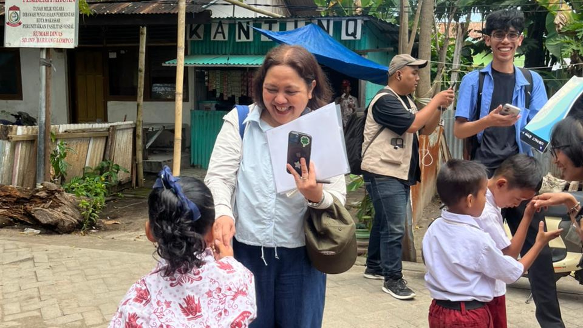 Peserta kegiatan PARKIR Makassar berinteraksi dengan anak-anak di Pulau Barrang Lompo saat melakukan transect walk untuk melihat langsung kondisi layanan publik dan kehidupan masyarakat kepulauan, Kamis (23/4/2026).
