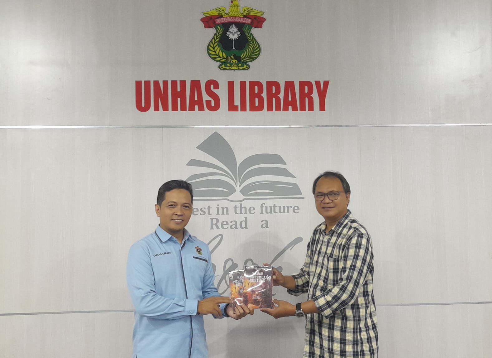 Penyerahan Buku KAMAR PERTEMUAN SENIMAN untuk Koleksi Perpustakaan Unhas , Rusdin Tompo Koordinator SATUPENA Sulawesi Selatan (kanan), menyerahkan buku kepada Sekretaris Perpustakaan Universitas Hasanuddin, Anshar Saud (kiri), di Perpustakaan Unhas, Makassar.