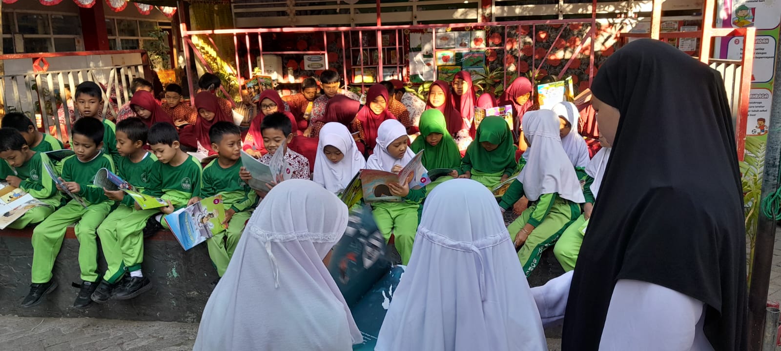 Suasana aktivitas Rabu Literasi di SD Negeri Borong, Makassar. Murid-murid antusias membaca buku selama 15 menit di area panggung pertunjukan seni sebelum jam pelajaran dimulai.